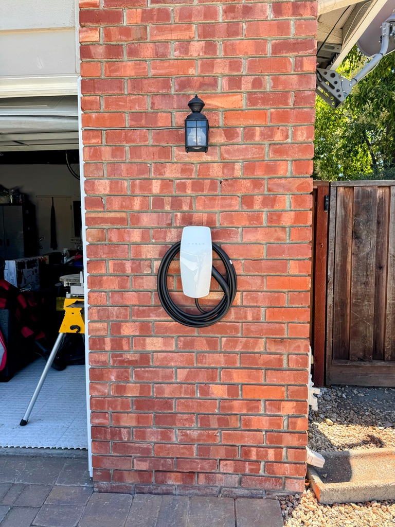 Tesla Wall Connector installed on a brick wall
