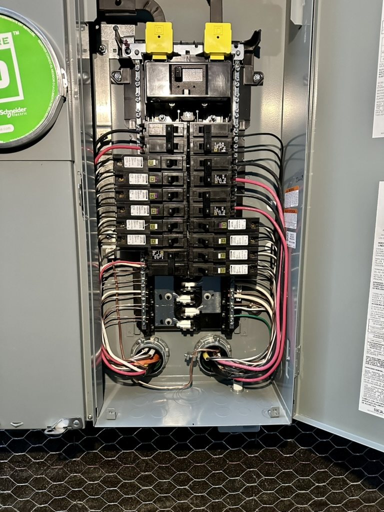 Interior of a residential electrical panel with neatly arranged breakers and conductors